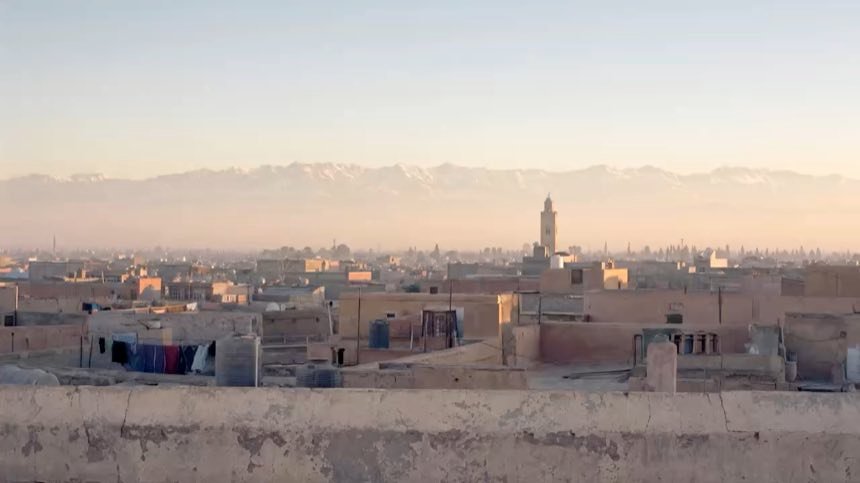Azoteas de Marrakech al amanecer con la línea nevada del Atlas al fondo.