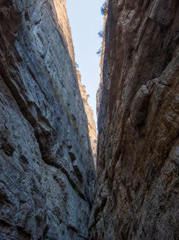 Gargantas de piedra altísimas con una franja de cielo arriba.